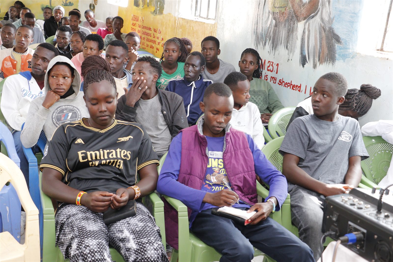 Young people listening and taking notes during a Camp Hope learning session